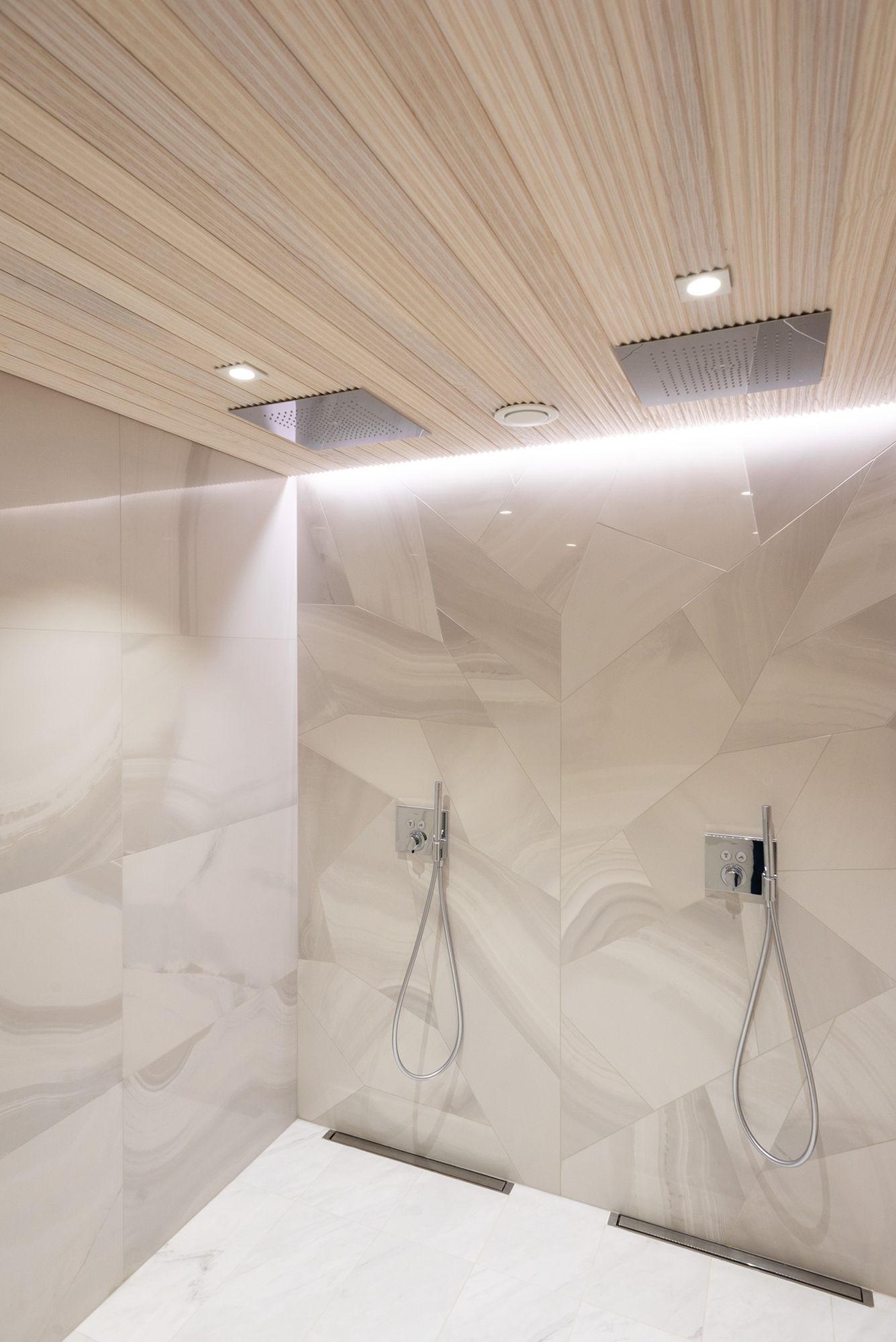 Led strip installed between the ceiling and the wall to highlight the shower wall and the tiling. Two spots in front of the showers to support the strip. Ledstore.fi